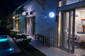 A modern hotel with a pool, a moon mural, and a well-lit entrance. - Luxury 3-BR Villa, Canggu Berawa , Private Pool (Kec. Kuta Utara)
