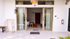 A building entrance with a number '3' above the door, a fire extinguisher on the wall, and a small outdoor seating area with a table and chairs. - Luxury 3-BR Villa, Canggu Berawa , Private Pool (Kec. Kuta Utara)