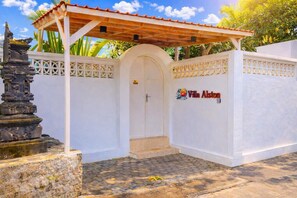 A gated entrance with a covered porch, a stone pedestal, and a sign for 'Villa Alston.' - Luxury 3-BR Villa, Canggu Berawa , Private Pool (Kec. Kuta Utara)