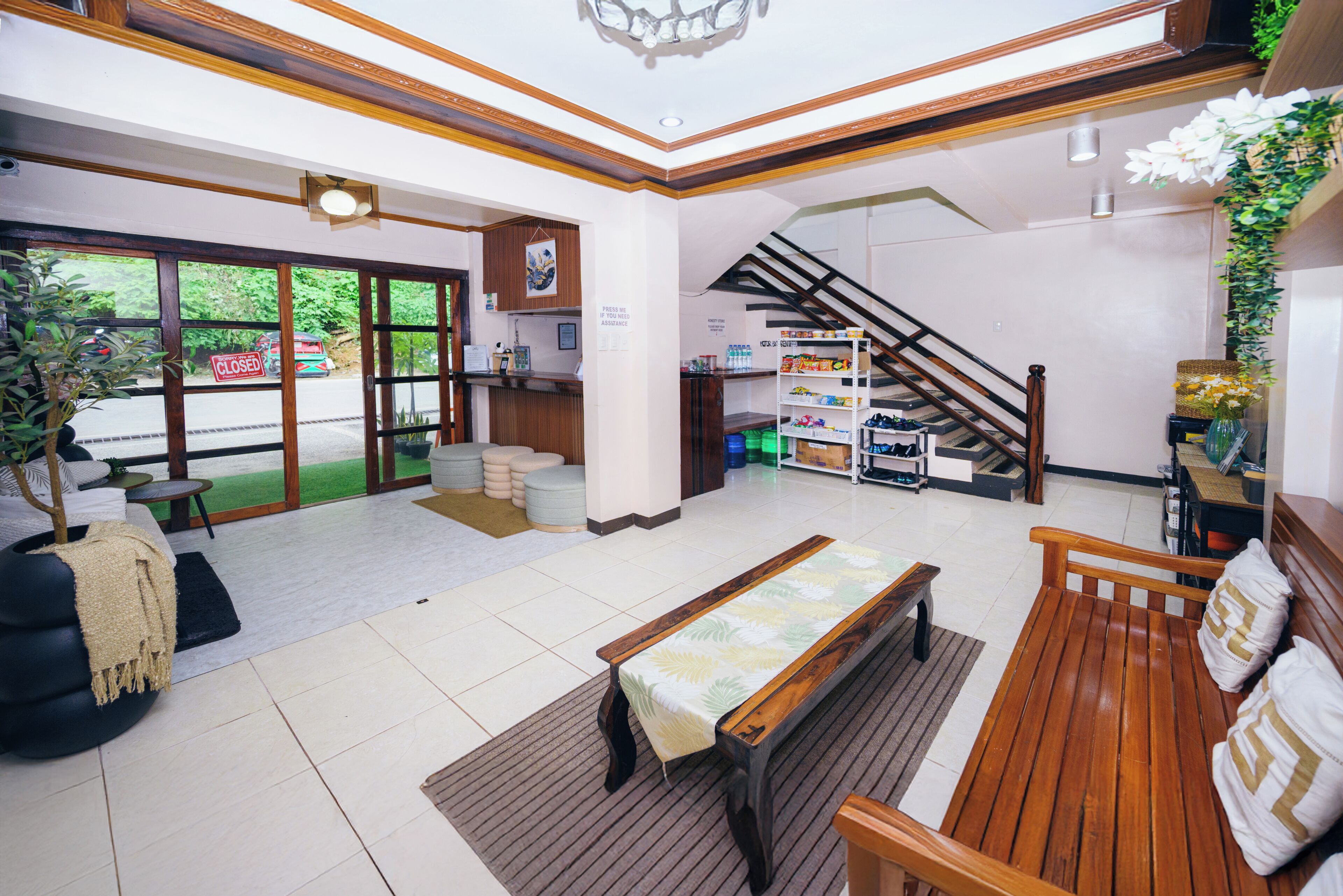 A spacious lobby with a reception desk, seating area, and a staircase.