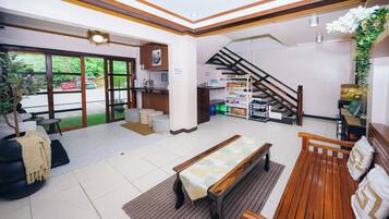A spacious lobby with a reception desk, seating area, and a staircase.
