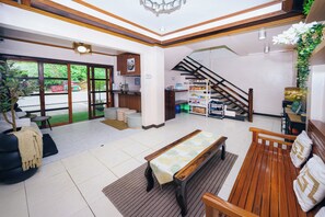 A spacious lobby with a reception desk, seating area, and a staircase. - Silverise Guest House (El Nido)