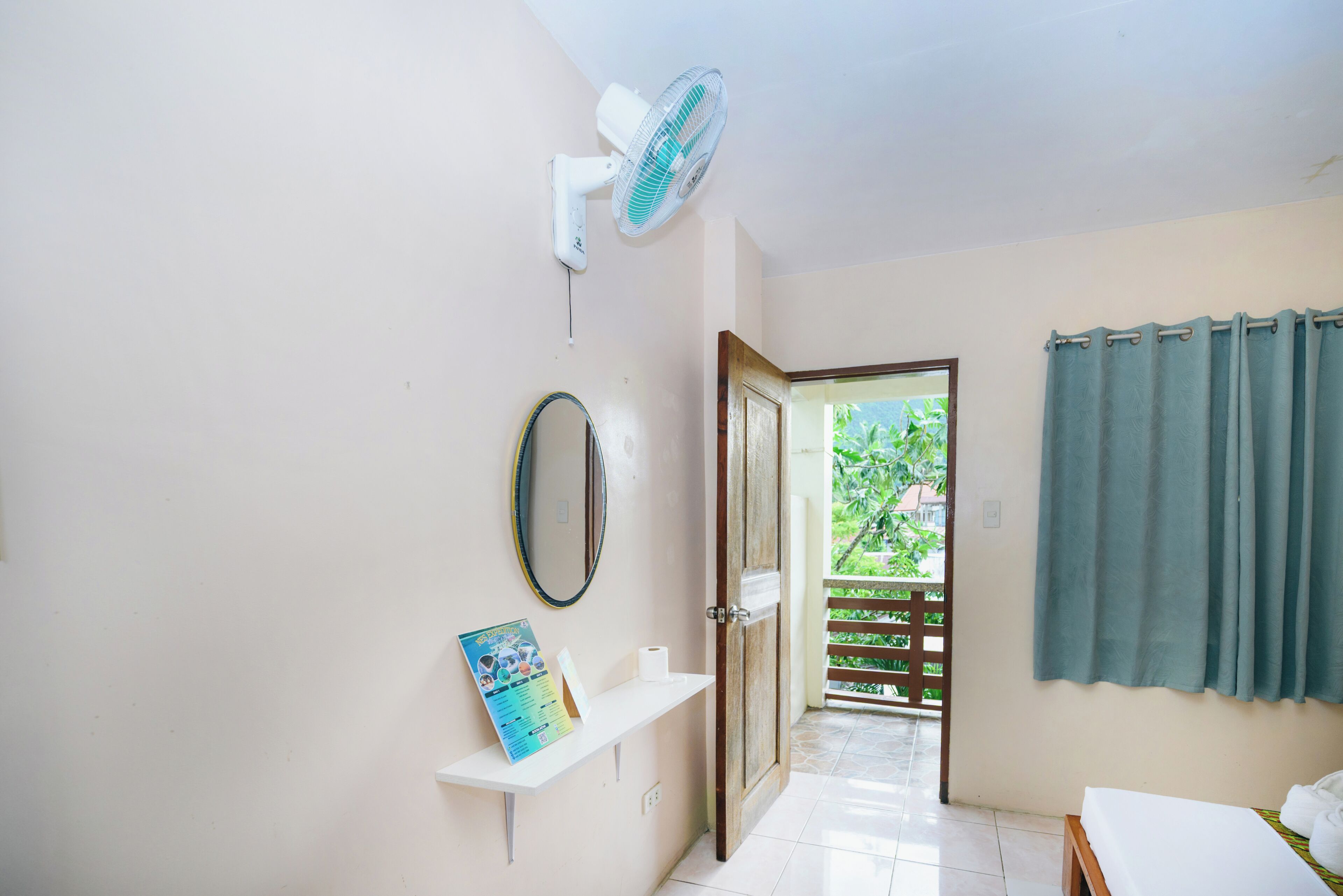 Un baño con lavamanos blanco, espejo, toallero y cortina de ducha.