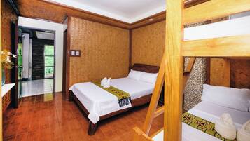 A room with a wooden bed, a wooden bunk bed, and a wooden floor.