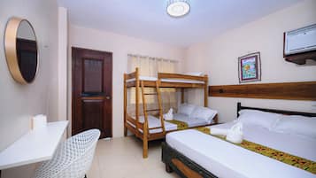A room with a bunk bed, a desk, a chair, a door, a window with curtains, and a wall-mounted air conditioner.