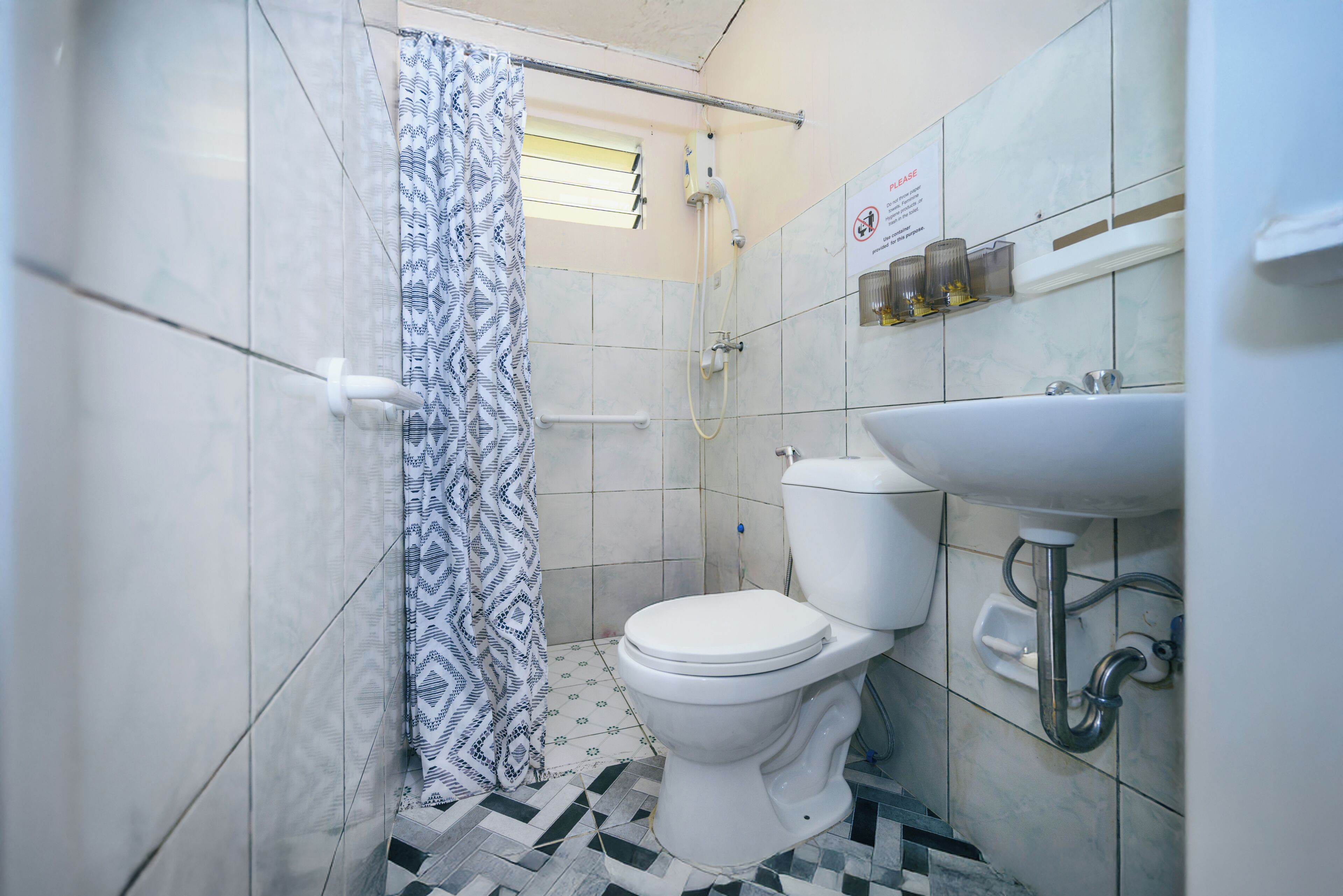 A bathroom with a toilet, a sink, and a shower.
