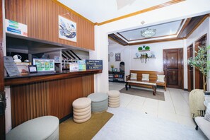 Un área de recepción con mostrador de madera, un banco y una puerta con la etiqueta '3'.