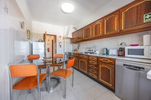A kitchen with wooden cabinets, a stainless steel refrigerator, a microwave, and a dishwasher. - Apartment 'Central  - Lagos' with Sea View, Balcony and Wi-Fi (Lagos)