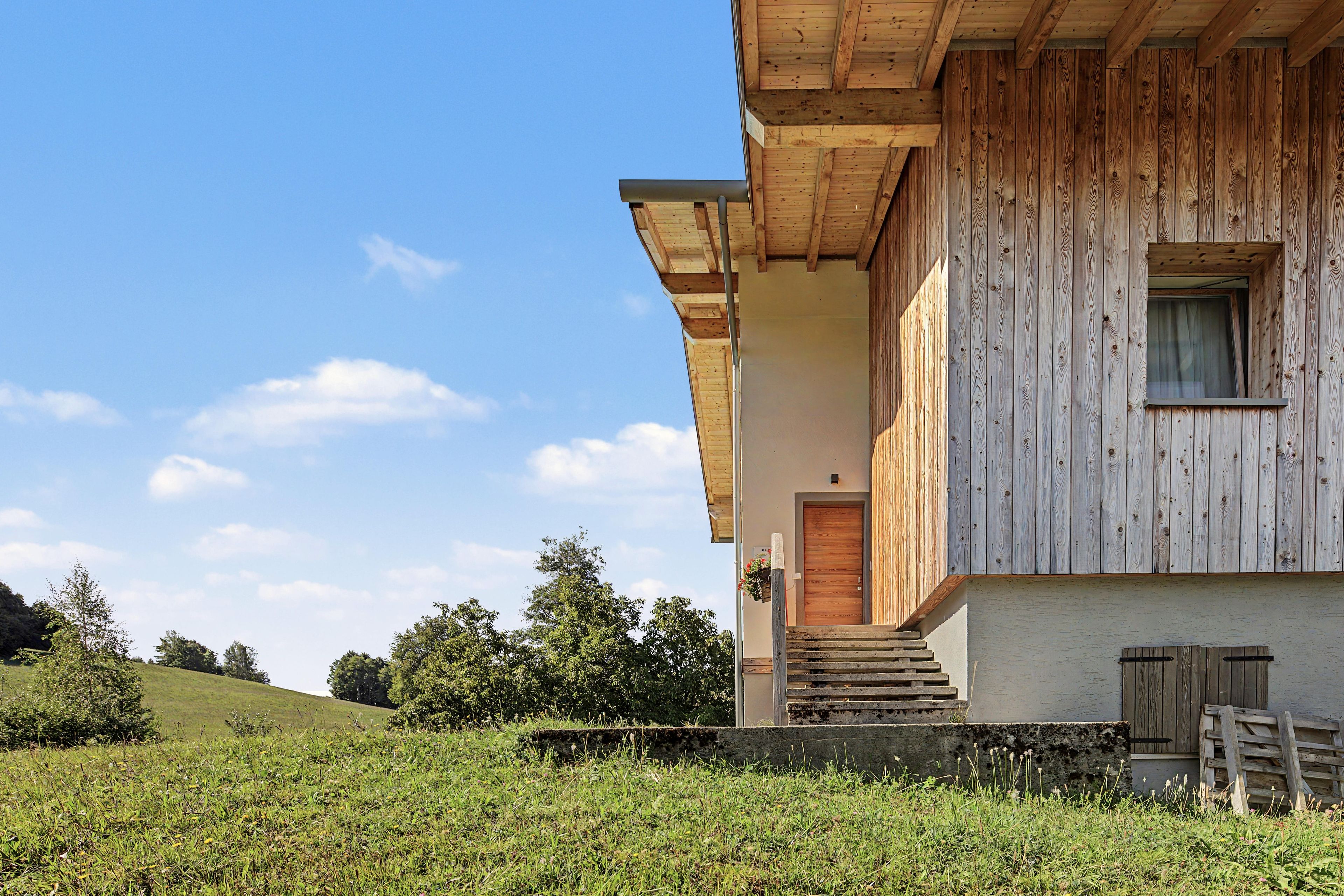 Un bâtiment en bois avec une entrée bien visible et une fenêtre.