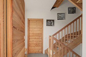 A wooden staircase with a handrail, a wooden door, and two framed pictures on the wall. - Bed and Breakfast 'Formigher' with Mountain View and Wi-Fi (Limana)