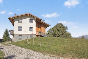 A two-story building with a sloped roof, wooden exterior, and a small balcony. - Bed and Breakfast 'Formigher' with Mountain View and Wi-Fi (Limana)
