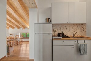 A modern kitchen with white cabinetry, a stainless steel refrigerator, and a countertop with a coffee maker. - Bed and Breakfast 'Formigher' with Mountain View and Wi-Fi (Limana)