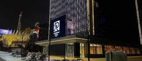 A hotel with a prominent sign, a covered entrance, and snow on the ground.