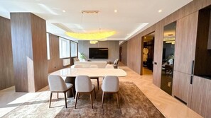 A modern dining area with a large table, four chairs, and a chandelier. - Resident Hotel Abay  (Almaty)