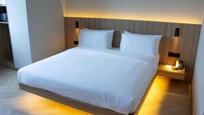 A modern hotel room with a bed, bedside tables, and a built-in headboard. - Resident Hotel Abay (Almaty)