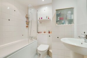 Een badkamer met een bad, toilet en wastafel.