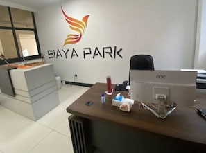 A reception desk with a computer, a water bottle, and a tissue box. - Siaya Park - Elevate Stay (Kangundo)