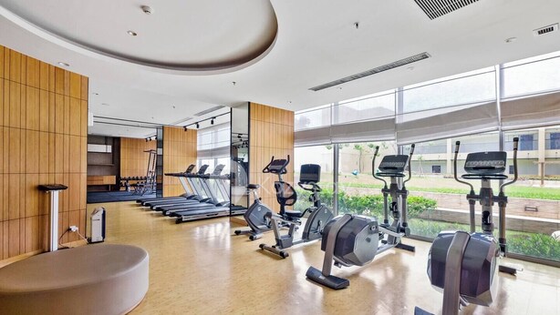 Et moderne fitnesscenter med løbebånd, crosstrainere og romaskine.