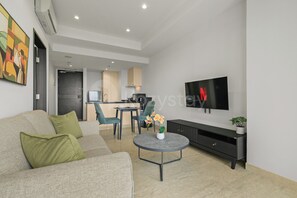 Ein modernes Wohnzimmer mit einer Couch, einem Couchtisch und einem Flachbildfernseher.