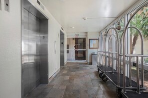 A hallway with elevators, a trash bin, and a security camera. - Mahana Resort |  2 Oceanfront Villas, Sleeps 8 | Car Incl. w/ 6+Nights | ML-4190 by KBM (Lahaina)