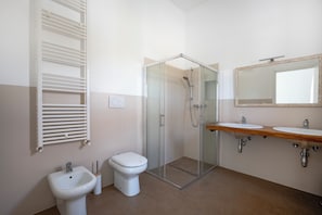 A bathroom with a shower, bidet, and two sinks. - Beyond the Cones (Puglia)