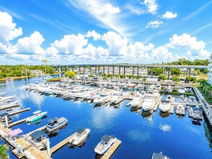 A marina with boats docked, a bridge in the background, and a clear sky. - Harbourgate Resort and Marina 504 (North Myrtle Beach)