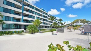 Ein modernes Hotel mit mehreren Etagen, einem Poolbereich und Blick auf den Strand.