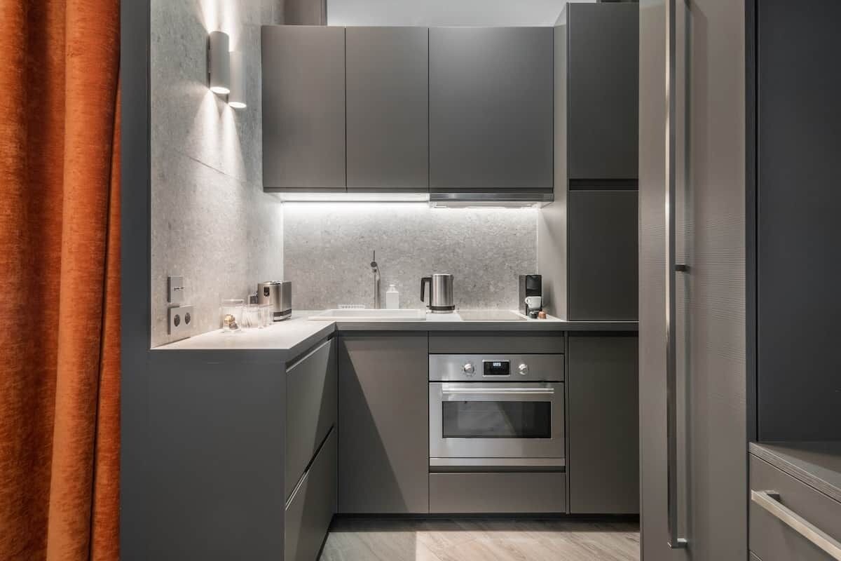 A modern kitchen with stainless steel appliances, a built-in oven, and a countertop with a coffee maker.