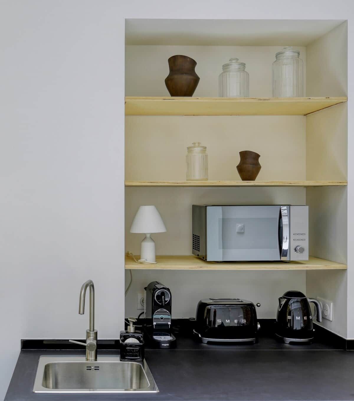A compact kitchenette with a sink, microwave, toaster, and coffee maker.