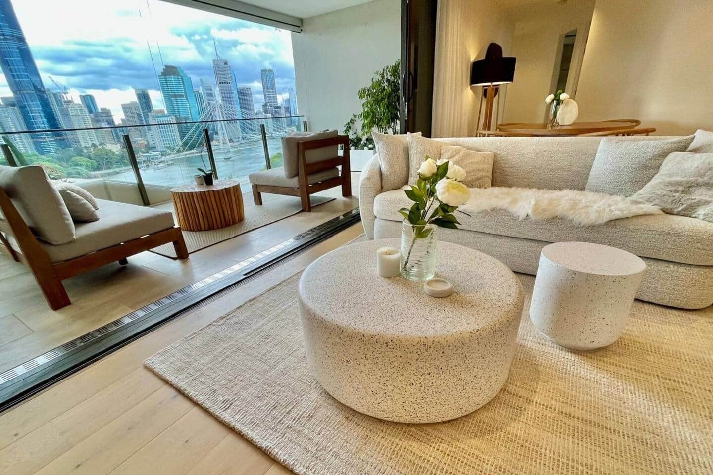 A modern living room with a city view, a sofa, a coffee table, and a side table.