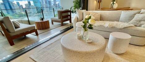 A modern living room with a city view, a sofa, a coffee table, and a side table.