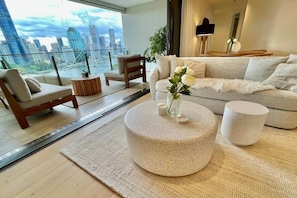 A modern living room with a city view, a sofa, a coffee table, and a side table. - Luxury 2BR Apt, Pool, Parking, Skye Kangaroo Pt (Kangaroo Point)