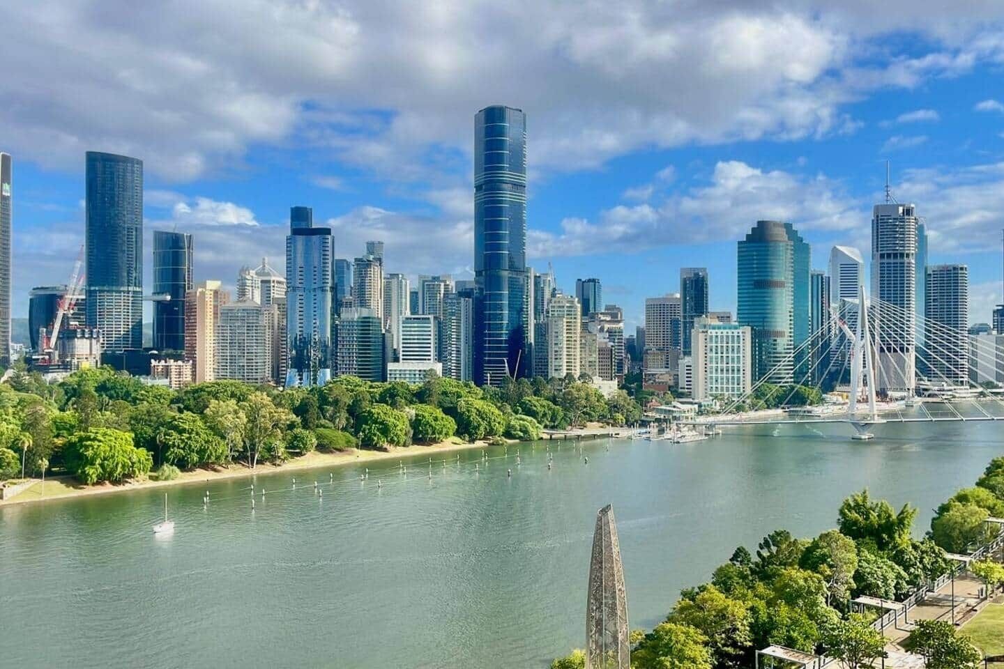 Eine moderne Stadtlandschaft mit Wolkenkratzern, einem Fluss und einer Brücke.