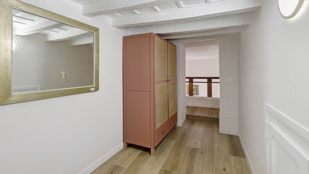 A hallway with a mirror, a wardrobe, and a staircase leading to another room. - Apartment 'Navona Haven' with Wi-Fi and Air Conditioning (Rome)