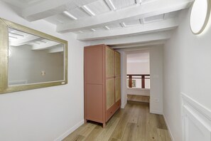 Ein Flur mit Spiegel, Kleiderschrank und einer Treppe, die in ein weiteres Zimmer führt.