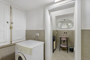 A laundry room with a washing machine, a sink, and a mirror. - Apartment 'Navona Haven' with Wi-Fi and Air Conditioning (Rome)