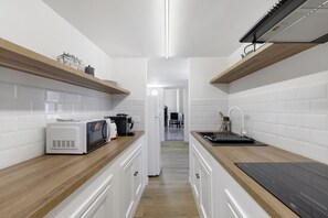 A modern kitchen with white cabinetry, wooden countertops, and a built-in microwave. - Apartment 'Navona Haven' with Wi-Fi and Air Conditioning (Rome)