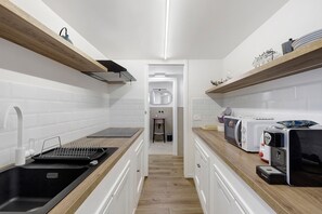 Eine moderne Küche mit weißen Ziegeloptik-Fliesen, Holz Arbeitsplatten und integrierten Geräten.