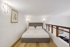 A hotel room with a bed, a headboard, a wooden railing, and a framed picture on the wall. - Apartment 'Navona Haven' with Wi-Fi and Air Conditioning (Rome)