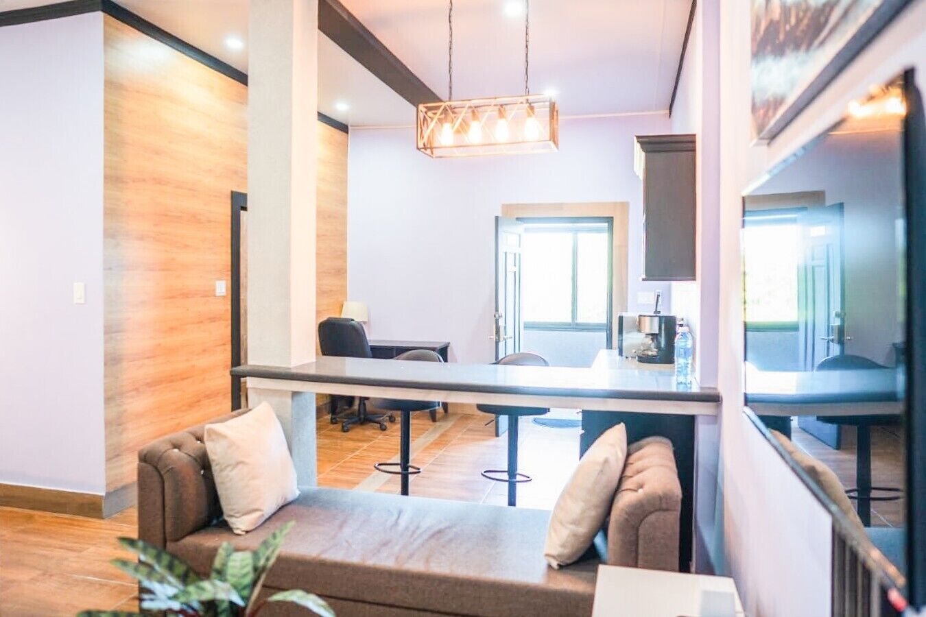 A modern interior with a sofa, a dining table, and a kitchen area.