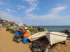 A beach with fishing equipment and boats, a clear sky, and a calm sea. - The Old Post Office (Ventnor)