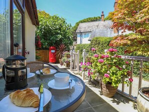 A patio with a table set for breakfast, including croissants, coffee, and tea. - The Old Post Office (Ventnor)