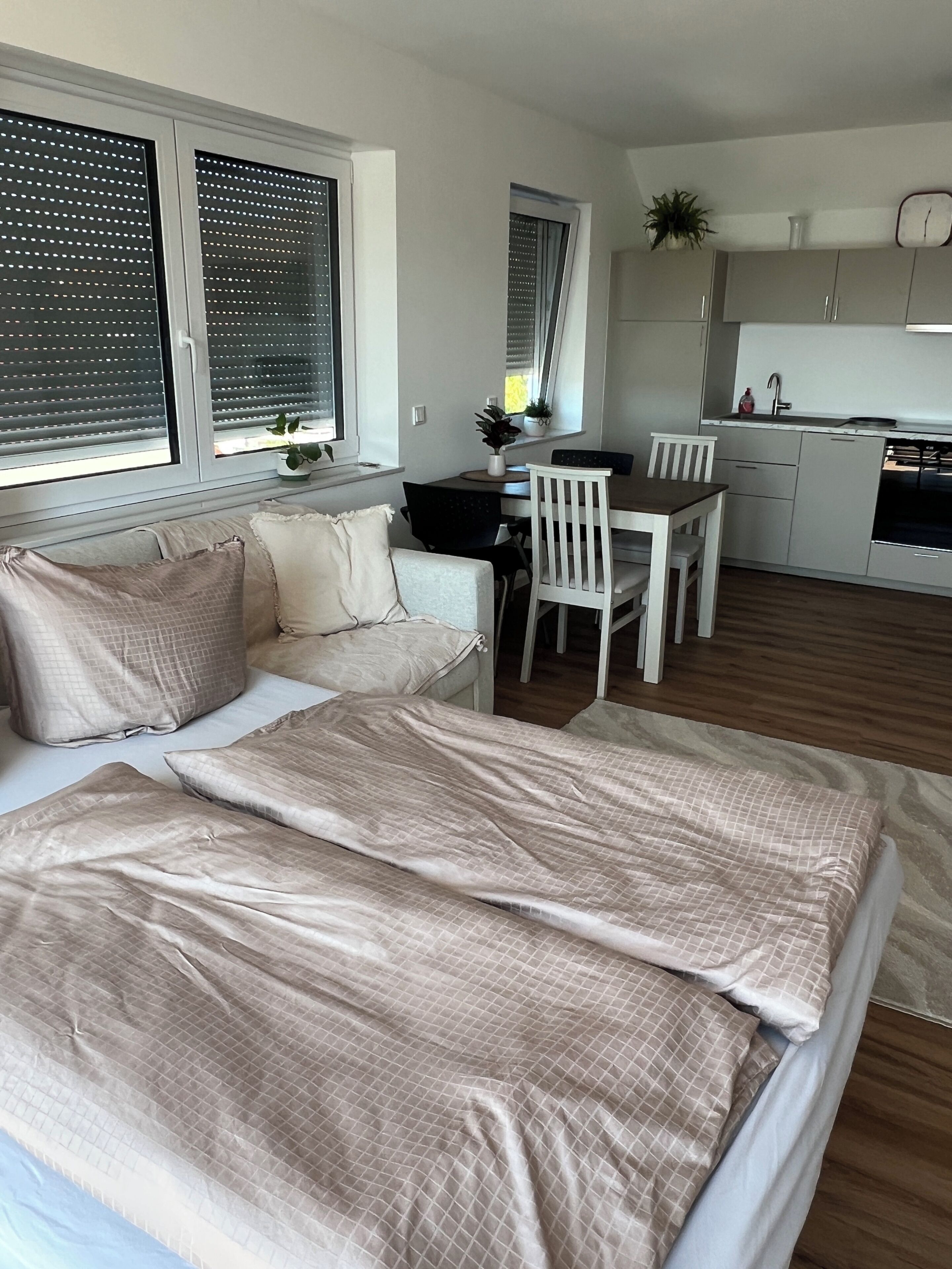 Ein Schlafzimmer mit einem Bett, einem Nachttisch und einem Fenster mit Jalousien.