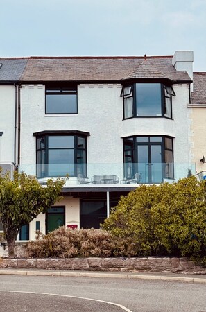 A two-story house with a flat roof, large windows, and a balcony. - Stunning family friendly Apartment with Balcony & Views (Deganwy)