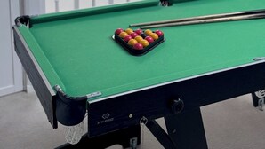 Een biljart met een keu en een set biljar balls.