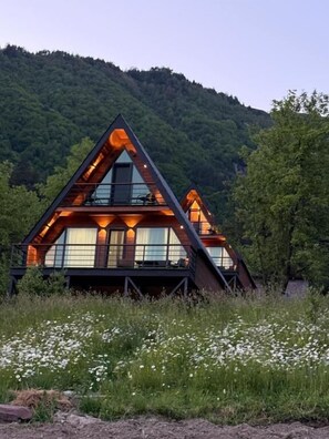 A cabin with a triangular roof, large windows, and a deck. - Horizon Mestia (Mestia)