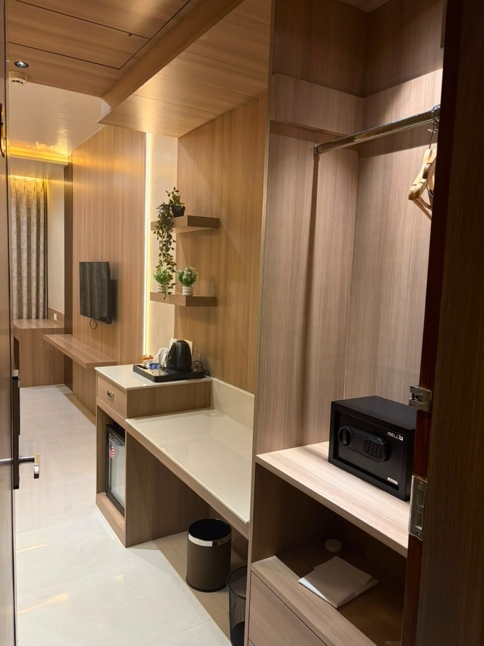 Un baño moderno con paneles de madera, ducha integrada, inodoro y lavabo con encimera.