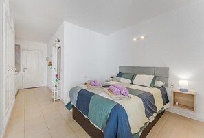 A bedroom with a bed, bedside table, and a nightstand. - Home Holidays 204 (CN)