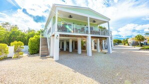 A two-story house with a covered porch and a single-story extension. - *NEW!*Life is a Marathon~VIEWS!~Pool~Dock~HotTub! (Marathon)
