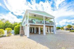 Ein zweistöckiges Haus mit überdachter Veranda und einem Anbau